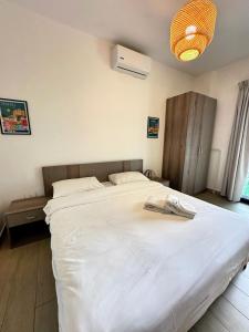 a bedroom with a large white bed in it at B-nine Batroun Central | Studio w/ Parking in Batroûn