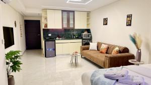 a living room with a couch and a kitchen at Amber – 10th Floor Sea View Studio, Kaslik in Jounieh