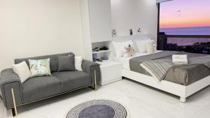 ein Schlafzimmer mit einem Bett, einer Couch und einem Fenster in der Unterkunft Candy in Jounieh