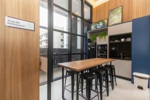 a kitchen with a wooden table and black stools at All Batel - Suyts in Curitiba
