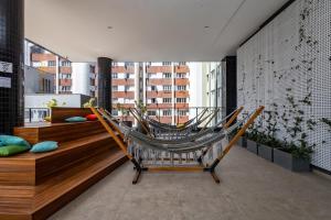 a hammock sitting on top of a balcony at All Batel - Suyts in Curitiba