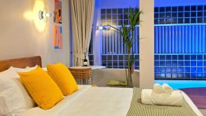 a bedroom with a bed with yellow pillows at Wanderlust HAUS in Ko Larn +21 photos