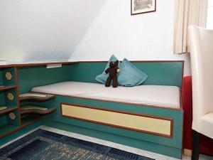 a teddy bear sitting on top of a bed at Ferienwohnungen Morsum - Bleicken in Morsum