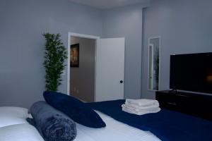 a bedroom with a bed with blue sheets and a flat screen tv at New York private room 31 in West New York +15 photos
