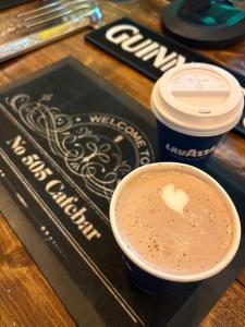 a cup of coffee and two drinks on a table at Abbey Meadows View ABB in Redditch