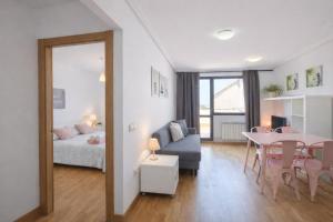 a living room with a table and a bed and a dining room at El Ático de Celorio – Piscina, Terraza y Playa in Celorio