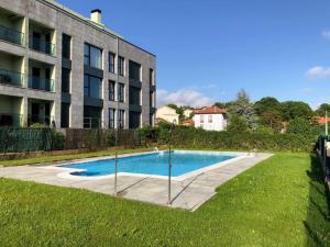 a swimming pool in front of a building at El Ático de Celorio – Piscina, Terraza y Playa in Celorio