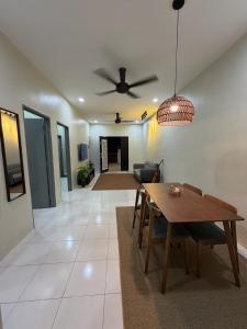 a living room with a table and a ceiling fan at Amara Homestay Gurun in Kampong Bongkok
