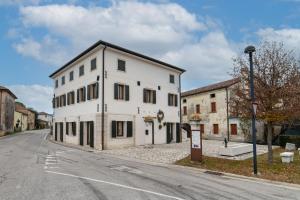 a white building on the side of a street at Locanda alla Nave in Pianzano