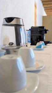a table with white cups and a coffee maker at Locanda alla Nave in Pianzano +5 photos