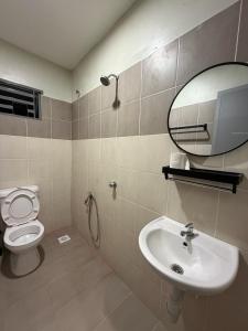 a bathroom with a toilet and a sink and a mirror at Amara Homestay Gurun in Kampong Bongkok +8 photos