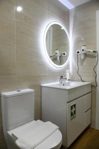 a bathroom with a white toilet and a mirror at Loreto Apartment in Bragança