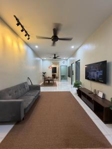 a living room with a couch and a flat screen tv at Amara Homestay Gurun in Kampong Bongkok