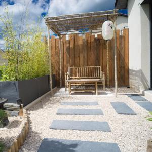 a bench sitting on a patio with a wooden fence at Kitsuné Lodge zen d'inspiration japonaise in Chaintré