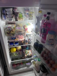 an open refrigerator filled with lots of food and drinks at Abbey Meadows View ABB in Redditch