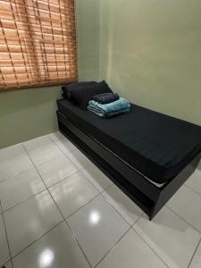a bed in a room with a black mattress at Amara Homestay Gurun in Kampong Bongkok