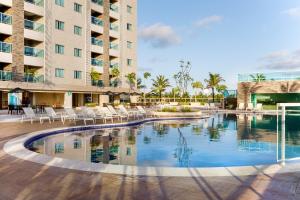 a pool at the resort with chairs and a building at PARK GAV Resorts in Salinópolis