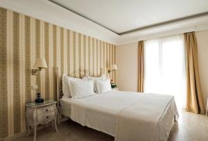 a bedroom with a large white bed and a window at Hotel Azimut in Sveti Stefan