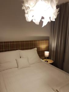 Un dormitorio con una cama blanca y una lámpara de araña. en CCH Elephant Apartments, en Poznan