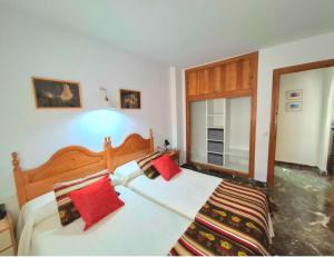a bedroom with a large bed with red pillows at Al Monacar vistas al mar, parking, aire acondicionado y wifi in Almuñécar