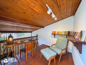 a room with a balcony with a table and chairs at Chalés Canoa in Ilhabela