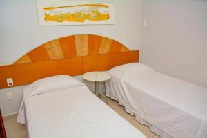 a bedroom with two beds and a small table at Garbos Soleil Hotel in Natal