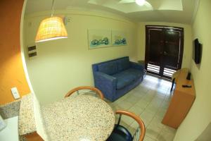 a living room with a blue couch and a table at Garbos Soleil Hotel in Natal