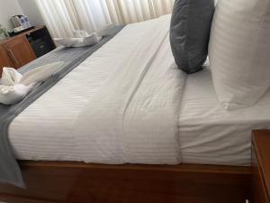 a bed with white sheets and pillows on it at inner pease in Nikawatawana