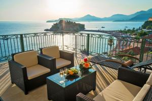 a balcony with chairs and a table with a view of the ocean at Hotel Azimut in Sveti Stefan