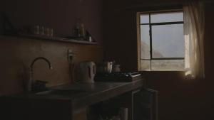 a kitchen with a sink and a window at Macondo - Casas entre cerros in Tilcara