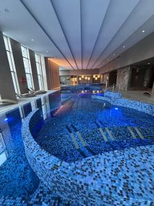 a large swimming pool with blue tiles in a building at APT. 539 in Dziwnówek