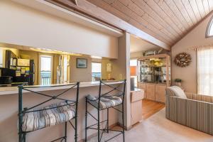 a kitchen and living room with a bar in a house at Ocean Song - 2 Bedroom Oceanfront Penthouse Condo in Kill Devil Hills, Spacious Layout in Kill Devil Hills