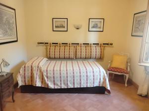 a bedroom with a bed and a chair at L'Alcova tra gli ulivi in Zoagli