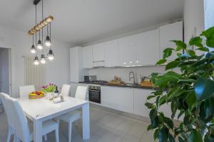 a kitchen with a white table and white cabinets at LAKE COMO BORGO VIGNOLA - Cozy Apartment in a Charming Village in Cremia