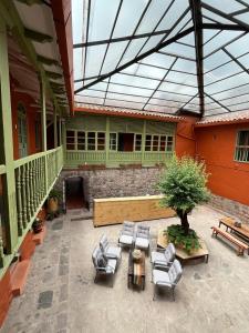 a patio with chairs and a table and a tree at Casa Terra Cusco in Cusco