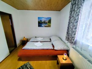 a small bedroom with a bed and a window at Dovolenkový dom Zuberec in Zuberec +34 photos