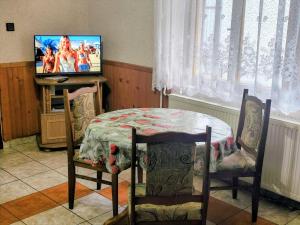 a dining room with a table and a television at Dovolenkový dom Zuberec in Zuberec