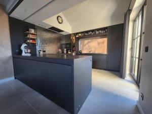 a kitchen with a black counter and a window at Obobonne in Geraardsbergen