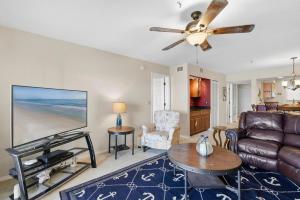 a living room with a couch and a tv at Bouchelle Island 203 in New Smyrna Beach