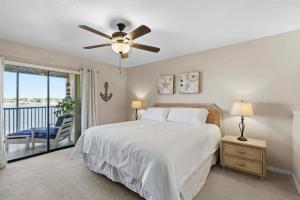 a bedroom with a bed and a ceiling fan at Bouchelle Island 203 in New Smyrna Beach +76 photos