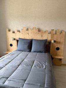 a bed with a wooden headboard in a bedroom at Les Cinq Étoiles in Remiremont