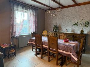 a dining room with a table and chairs and a window at Les Cinq Étoiles in Remiremont