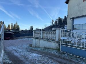 a fence in front of a house with snow on the ground at Les Cinq Étoiles in Remiremont