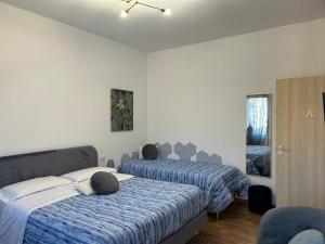 a bedroom with two beds with blue and white sheets at Comfort Accommodation Room in Bergamo