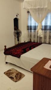 a bedroom with a large bed with a curtain at Oshi villa in Hikkaduwa