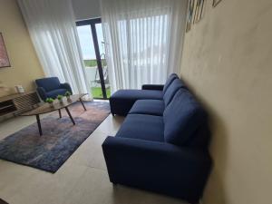 a living room with a blue couch and a table at chema in Cabo San Lucas +1 photo