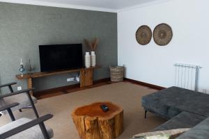 a living room with a television and a tree stump coffee table at Casa Oliveira in Fátima