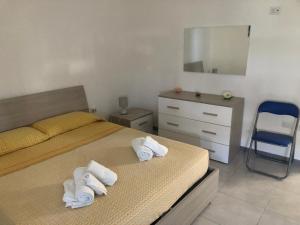 a bedroom with two beds and a dresser and a mirror at Casa Gada in Torre Lapillo