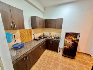 a kitchen with wooden cabinets and a counter top at La vida in Nalmatha +5 photos