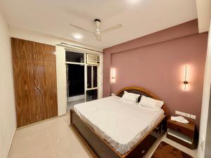 a bedroom with a bed and a pink wall at La vida in Nalmatha